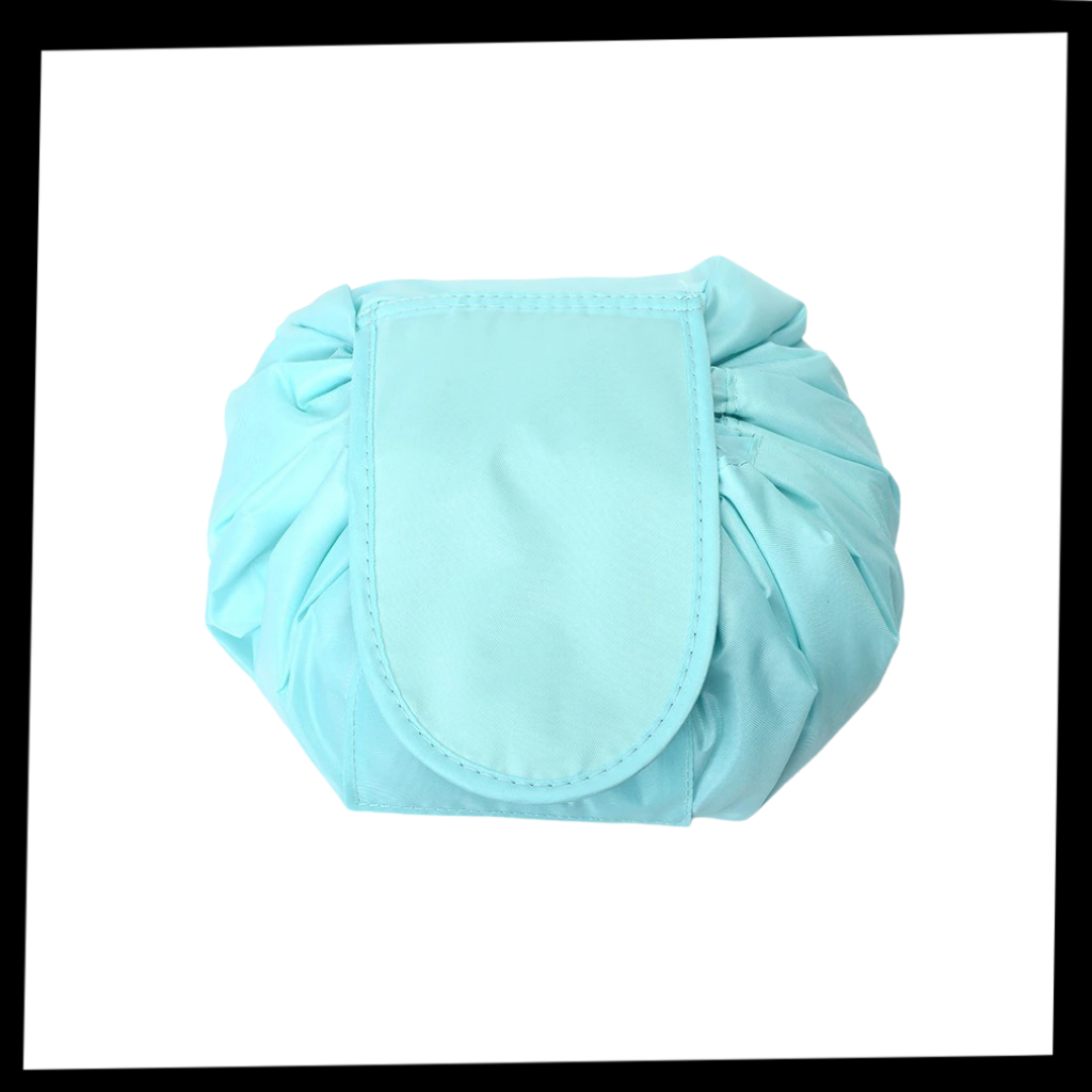 Necessaire de maquiagem dobrável com cordão de fechamento da marca Lay-N-Go, mostrado aberto com compartimentos internos.
