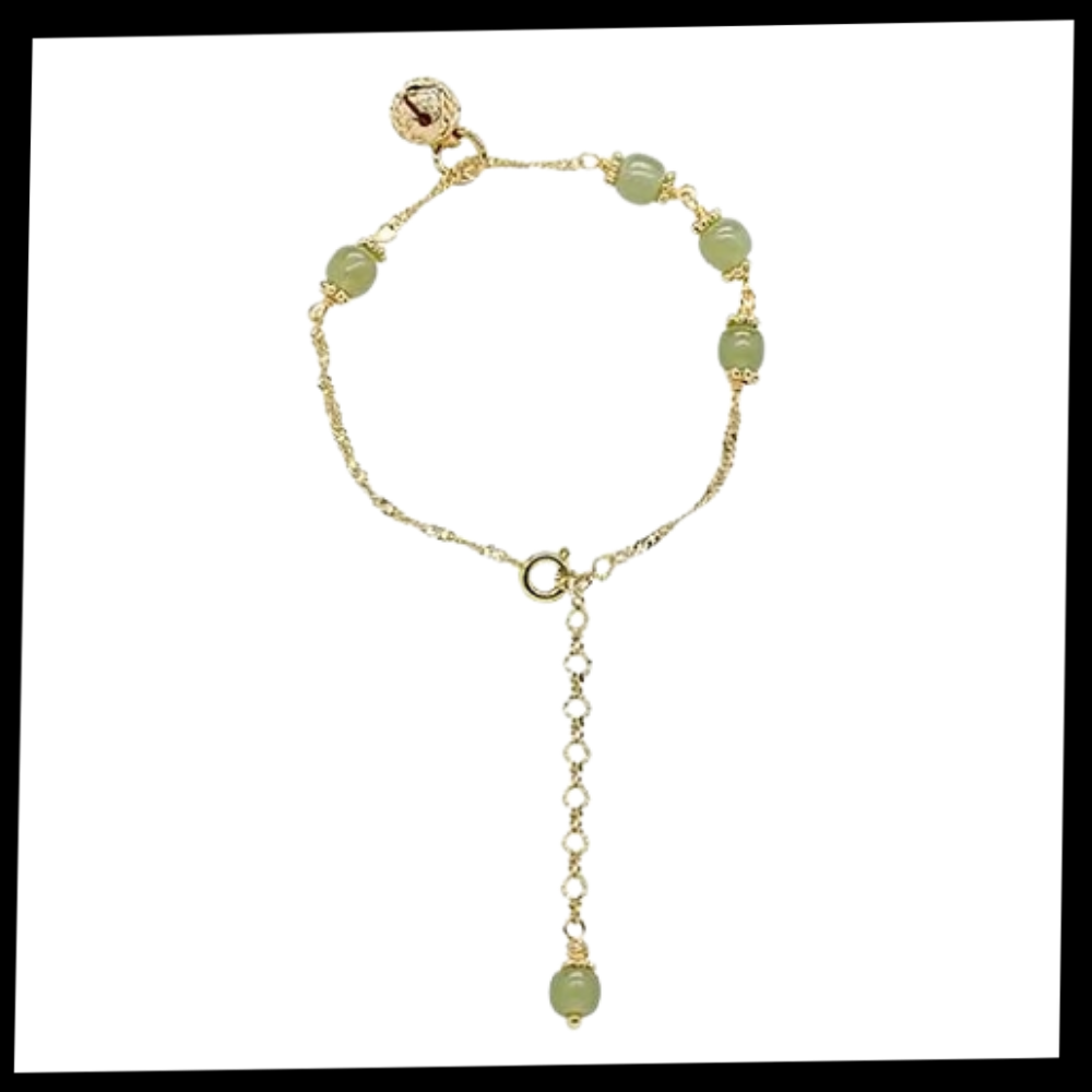 Pulseira de jade Hetian com sinos, acessório elegante da marca Falx, exibida em detalhe na imagem.