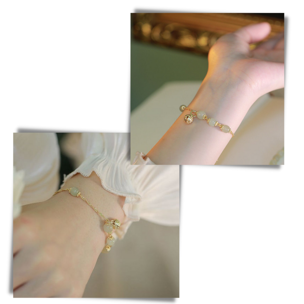 Pulseira de jade Hetian com pingentes de sino, feita pela marca Falx, exibindo detalhes do material e acabamento refinado.