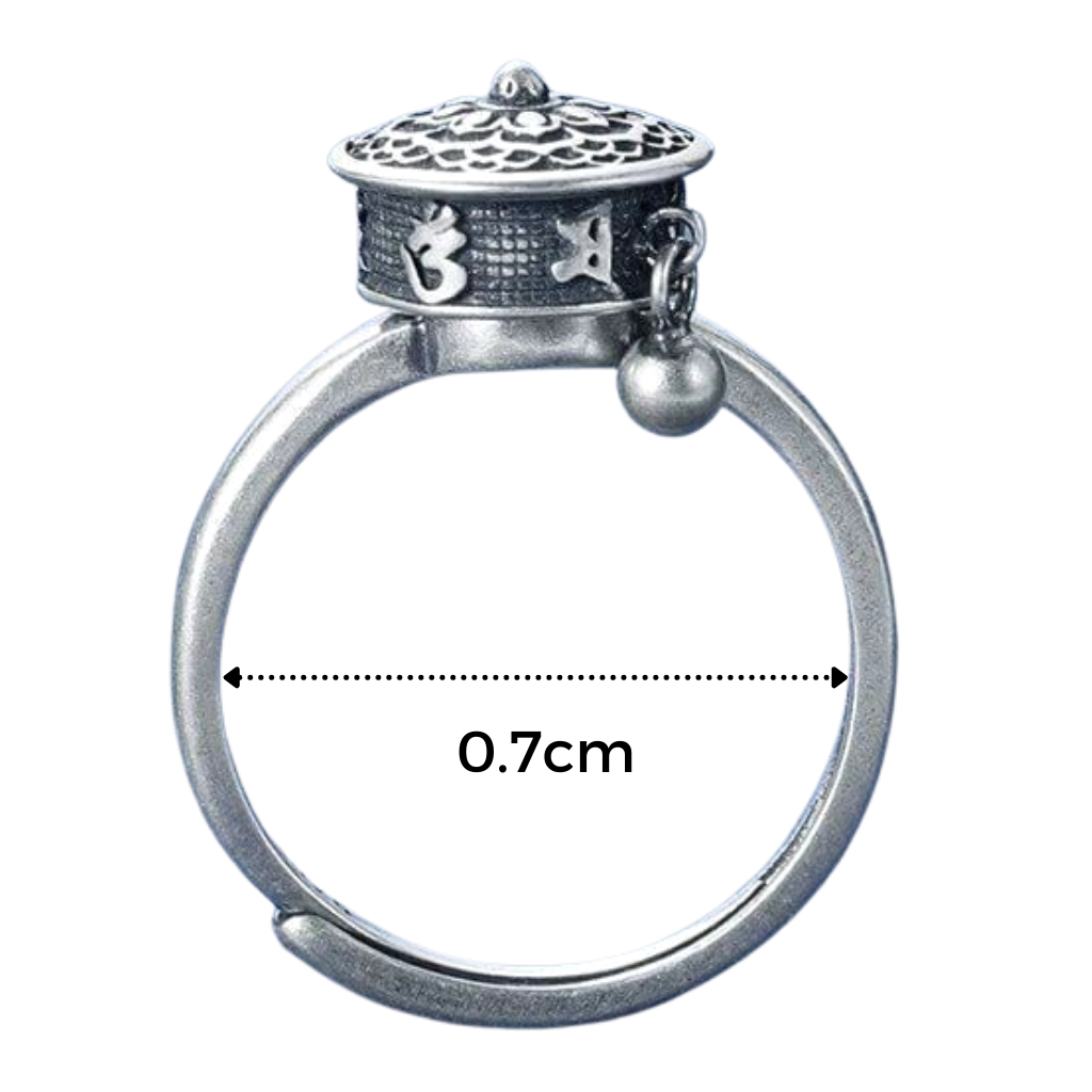 Anel feminino Freedx com mantra budista giratório, detalhe de design circular e acabamento metálico elegante.