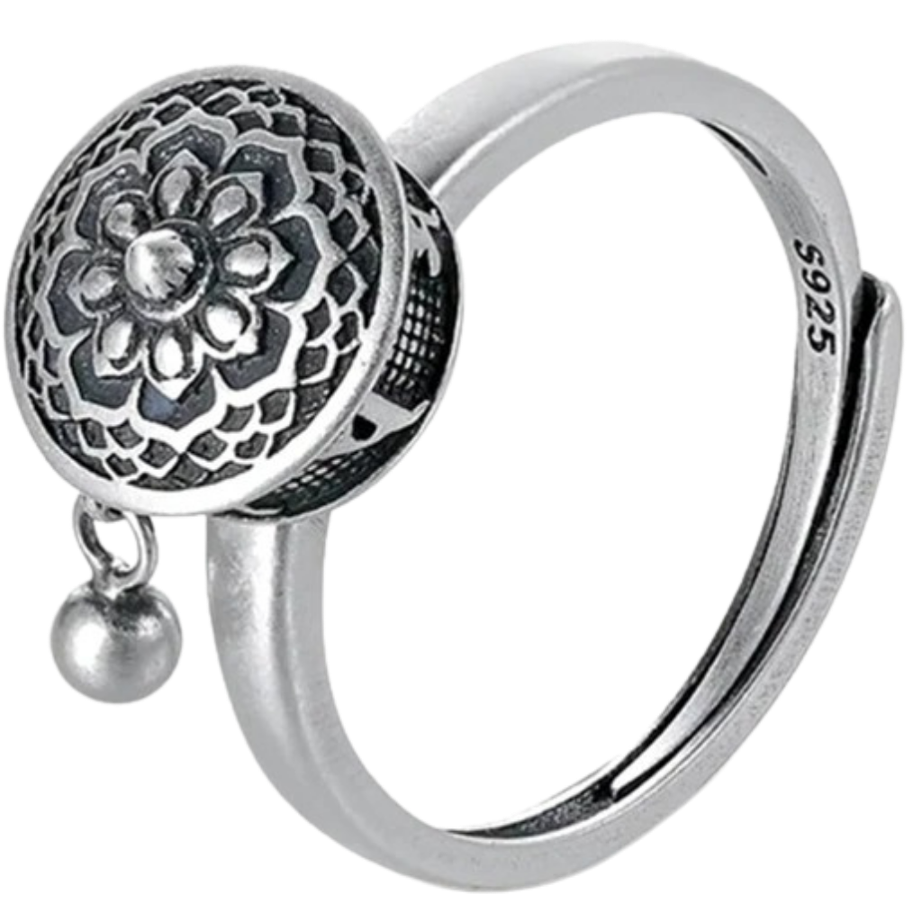 Anel feminino da Freedx com mantra budista rotativo, detalhe de design elegante e símbolo espiritual na superfície.